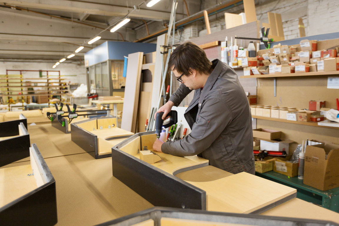 Assembler with Screwdriver Making Furniture